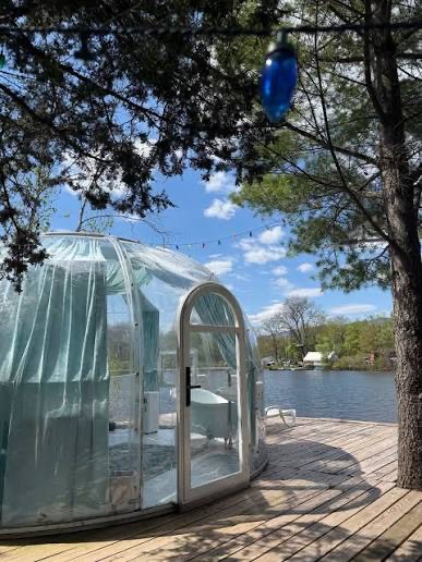 Glass relaxation dome on a wooden dock beside the lake at a Catskill NY spa